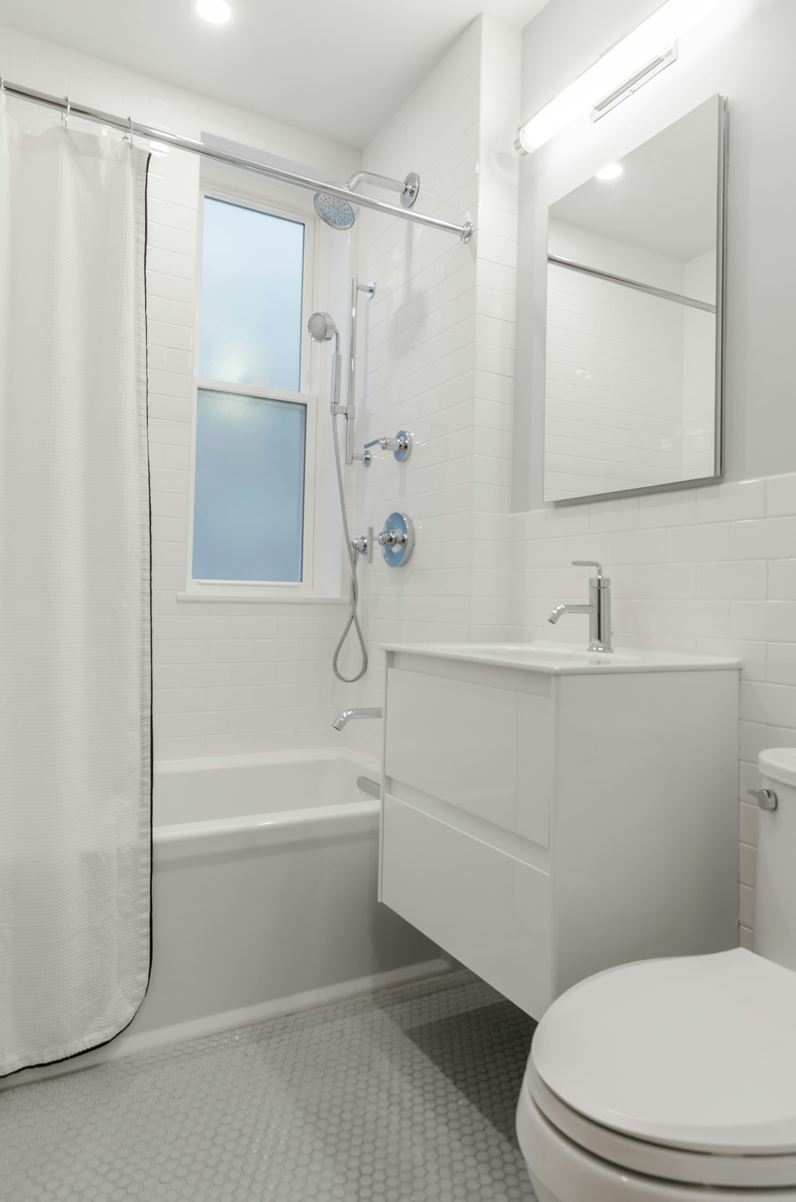 Finished bathroom with a tub and white tile